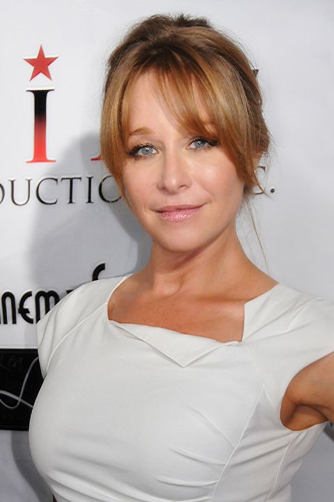 Jamie Luner poses a picture in a white dress.